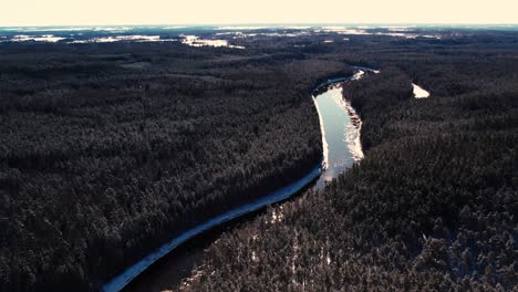 Un-Río-Sinuoso-Cerca-De-Un-Pequeño-Pueblo-Con-Un-Macizo-Forestal