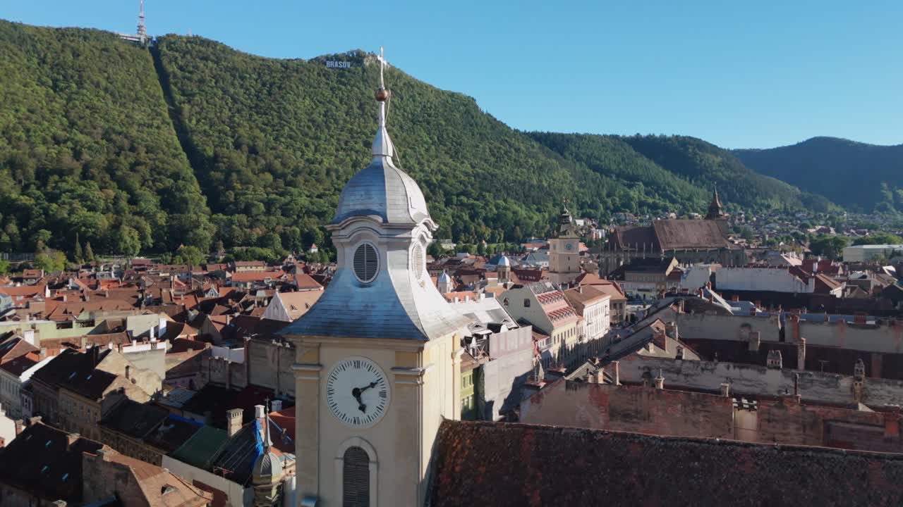Vista aerea della torre dell'orologio e del centro storico con colline sotto un cielo azzurro limpido