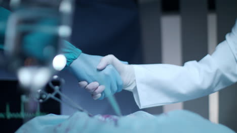 el cirujano, el médico, el apretón de manos. el equipo de cirujanos, felicitaciones. operación exitosa.