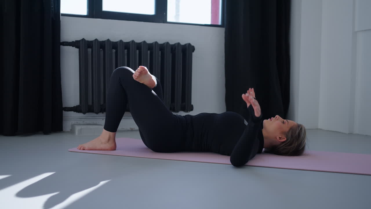 mujer practicando yoga en una alfombra