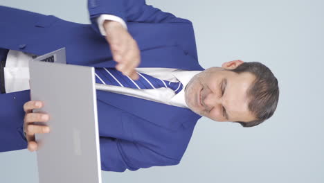 Vertical-video-of-An-angry-businessman-angrily-closes-his-laptop.