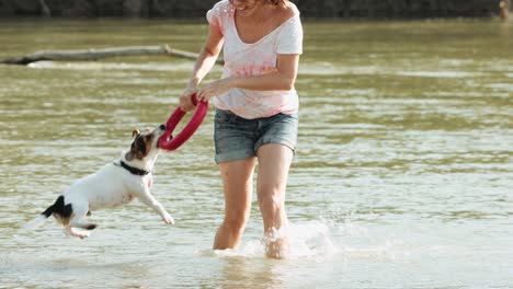 woman playing with dog near river