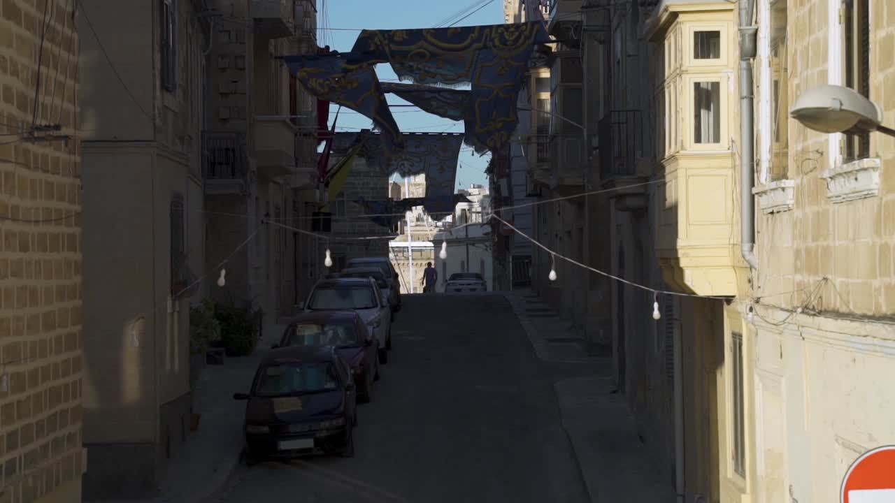 축제 기간 동안 깃발이 달린 몰타의 낡고 좁은 거리