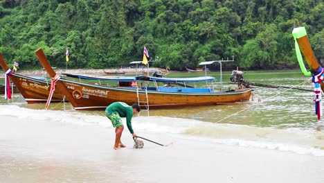 man approaches boat on krabi beach