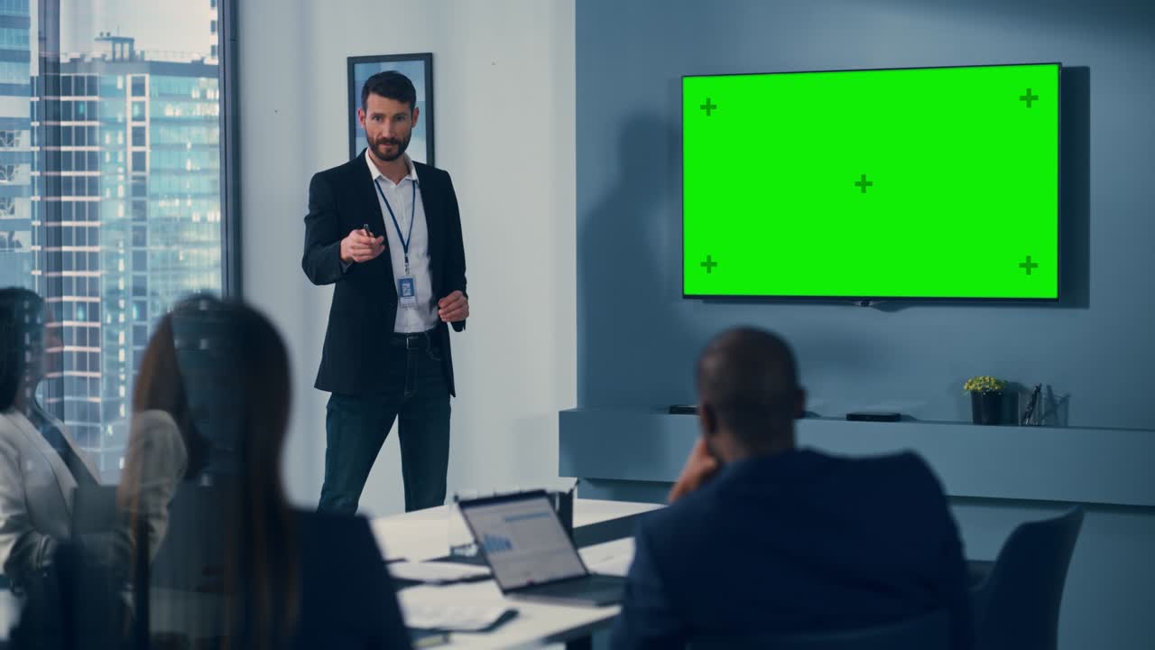 Office Conference Room Meeting Presentation: Handsome Businessman Talks, Uses Green Screen Chroma Key Wall TV. Successfully Presenting e-Commerce Product to Group of Multi-Ethnic Investors