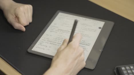 woman writing optometry notes on smart tablet in slow motion