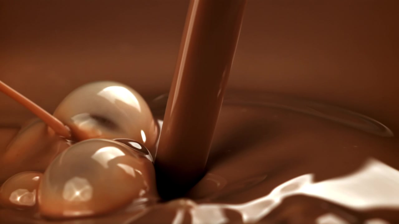 Flusso di cioccolato liquido che si versa e schizza al rallentatore