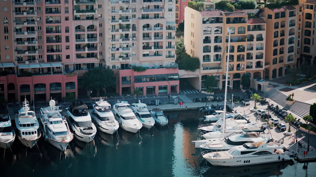 Aerial view of boats docked in the Monaco Marina with the skyline of the city on the background