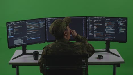 back view of tired asian man soldier developer yawning before sleeping while write code with multiple computer screens in green screen studio