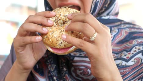 woman eating a bagel sandwich