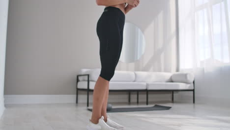 Cheerful-sportive-woman-doing-side-lunges.-Middle-aged-happy-sportswoman-living-room-doing-side-lunges-and-smiling-forward-while-training