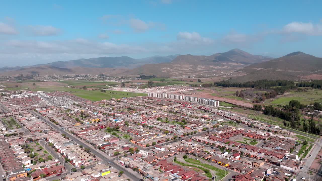 vista aérea panorámica de calles planificadas con complejos de viviendas entre las montañas nubladas