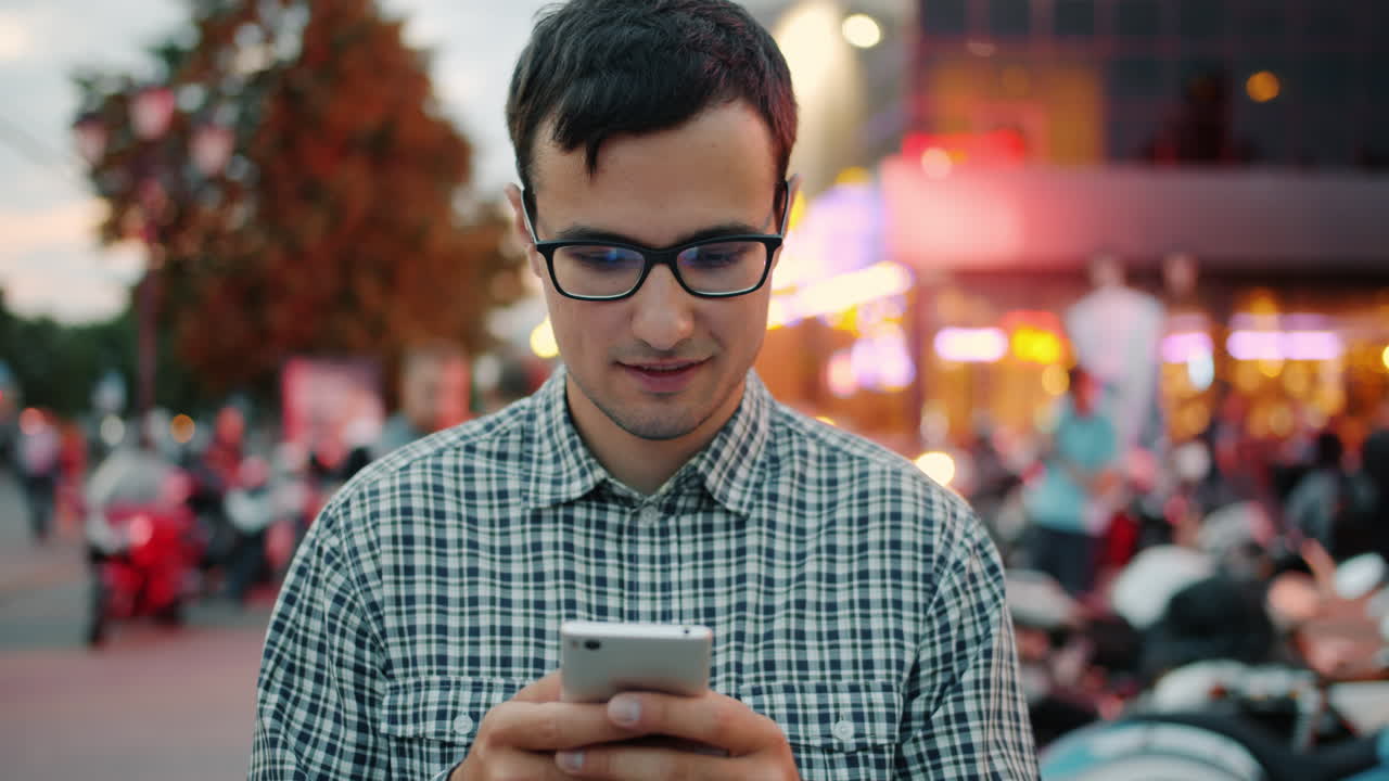 Joven usando smartphone en la ciudad de noche