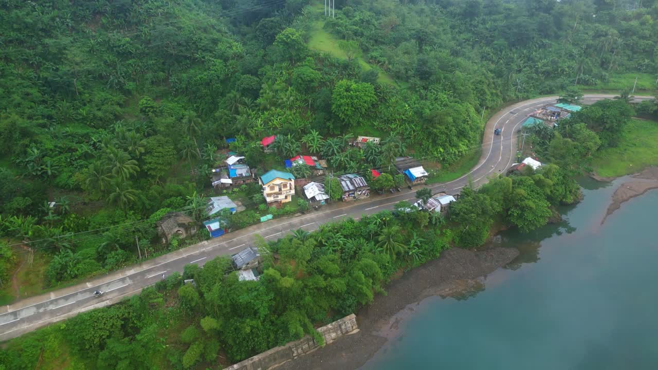 casas junto a la carretera cerca de montañas boscosas en la provincia rural de catanduanes, filipinas