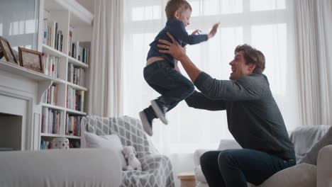 little-boy-jumping-into-fathers-arms-happy-dad-gently-catching-his-son-enjoying-playful-game-with-child-at-home-4k