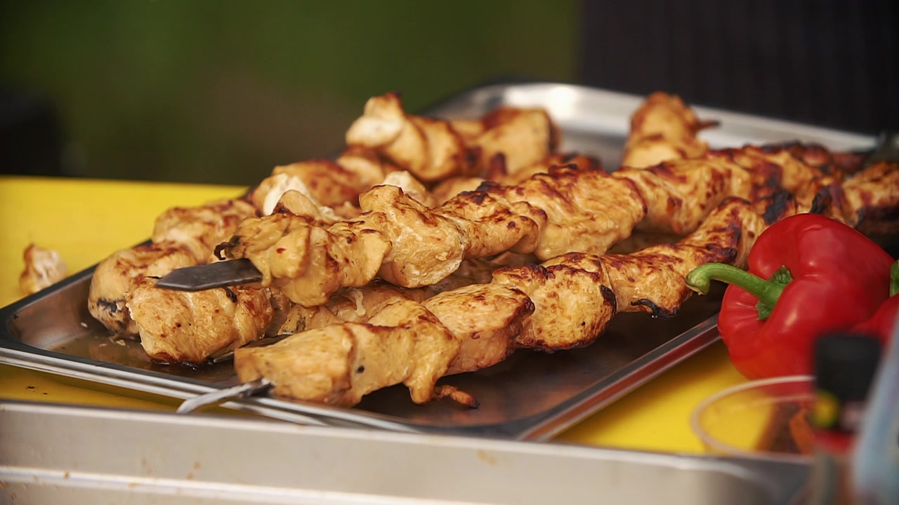 Primo piano di kebab di pollo cotto che viene servito