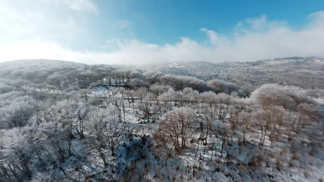Snow-covered mountain road, captured from a drone's perspective in bright daylight