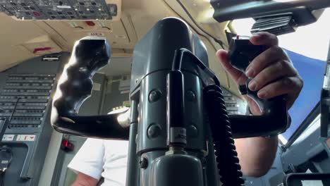 vista muy cercana de los controles de vuelo de un avión visto desde atrás mientras el piloto caucásico está volando