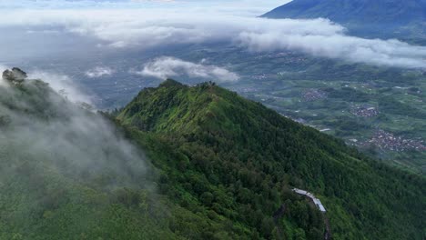 drone flying above misty mountain forest. lush greenery landscape on the hillside.