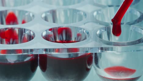 pipette filling wells of microplate with blood specimens in lab
