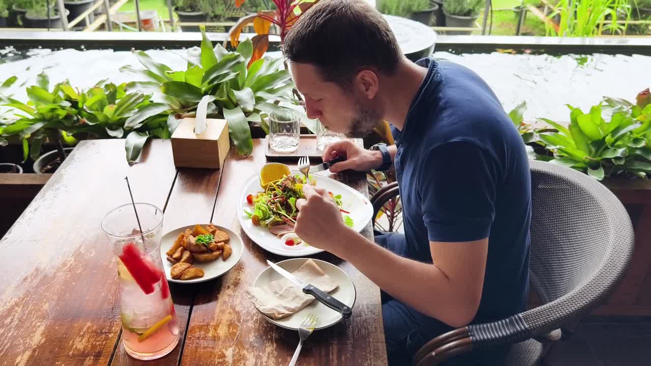 hombre comiendo ensalada en una cafetería