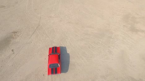 birds eye from the top view of an old american muscle car in a desert during a sunset