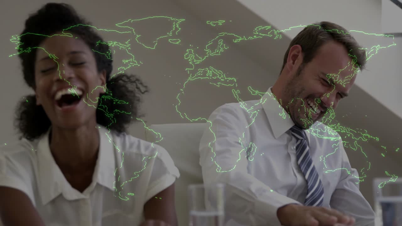Colleghi di lavoro che sentono un'osservazione divertente e ridono insieme, mentre una mappa del mondo verde neon pulsa.