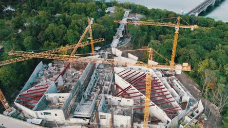 vista aérea construcción de un nuevo edificio con grúas de torre altas en área verde