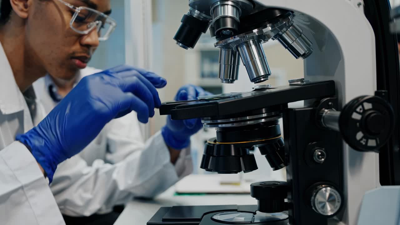 Wide-angle shot of a modern lab with scientists working, focusing on a researcher using