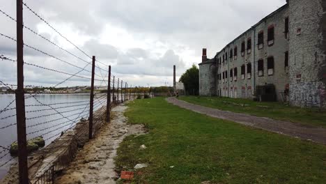 Close-up-panning-shot-of-Patarei,-abandoned-Soviet-prison-on-the-coast-of-the-Baltic-sea-in-Tallinn-with-panning-shot-revealing-heart-the-love-symbol-made-out-of-barbed-wire