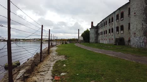 toma panorámica de cerca de patarei, prisión soviética abandonada en la costa del mar báltico en tallin con toma panorámica que revela el corazón, el símbolo del amor hecho de alambre de púas