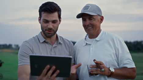 Lächelnde-Golfer-Nutzen-Ein-Tablet-Gerät-Und-Unterhalten-Sich-Online-Mit-Der-Familie-Auf-Dem-Golfplatz-Des-Country-Clubs