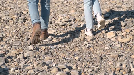 couples feet in shoes walking pebble stones. romantic couple walking on a beach