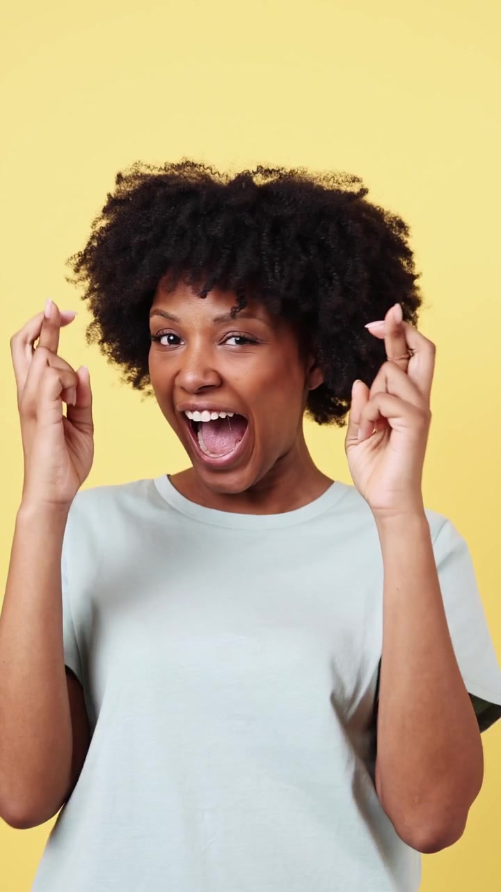 Jeune femme afro-américaine croisant les doigts et souriant
