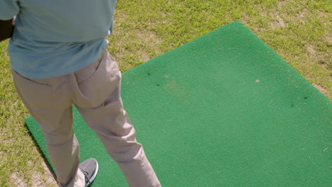 afro-amerikaanse man die golf oefent op de golfbaan.