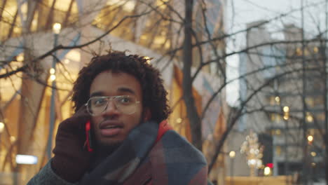 man talking on phone in a city during winter