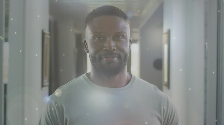 Animation of smiling african american man at home over white spots