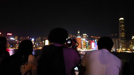 people enjoying hong kong's illuminated skyline