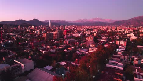 drone aéreo vuela sobre barrio italia barrio chileno al atardecer cordillera andina horizonte en tonos magenta, otoño en santiago de chile