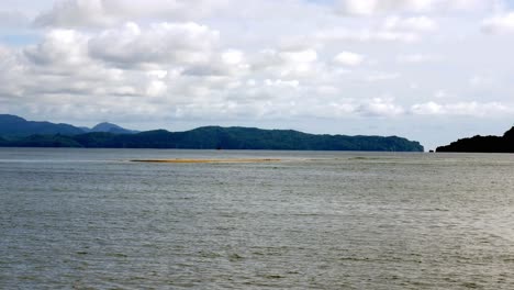 View-of-the-seaside-overlooking-the-sea-and-mountains-with-gentle-waves-on-a-holiday-in-good-weather,-Satun-Province,-Thailand