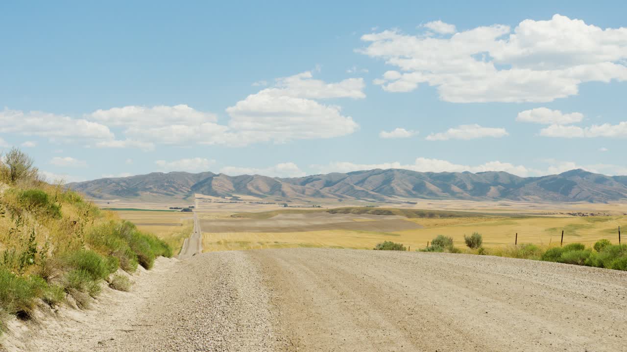 un largo camino rural que conduce a millas de granjas y tierras de cultivo en el este de idaho