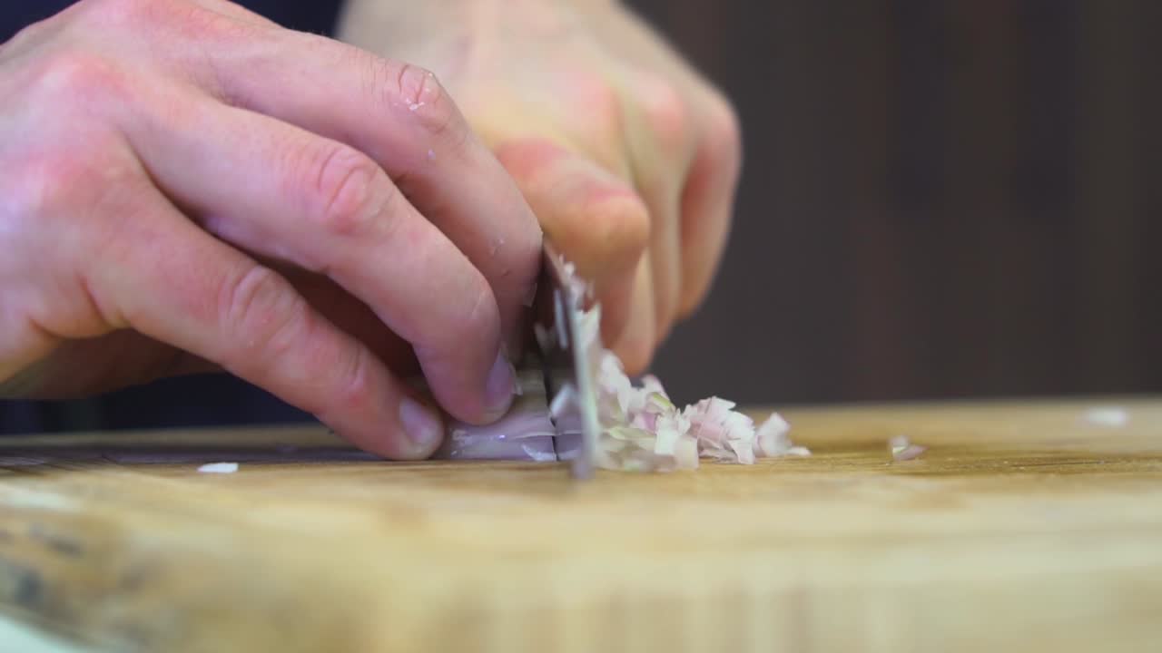 Chef finely dicing an organic shallot