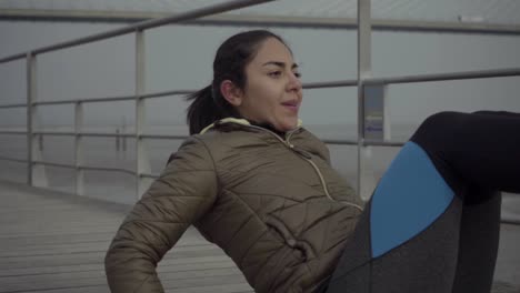 Concentrated-sporty-female-training-on-pier-at-seaside