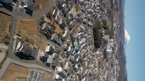 Inclinación-Vertical-Cinematográfica-Lenta-Hacia-Arriba-Sobre-La-Ciudad-Japonesa-Suburbana-Y-El-Monte-Fuji