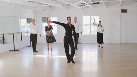 maestro de baile de raza mixta que toma una clase de baile de salón en un estudio de baile