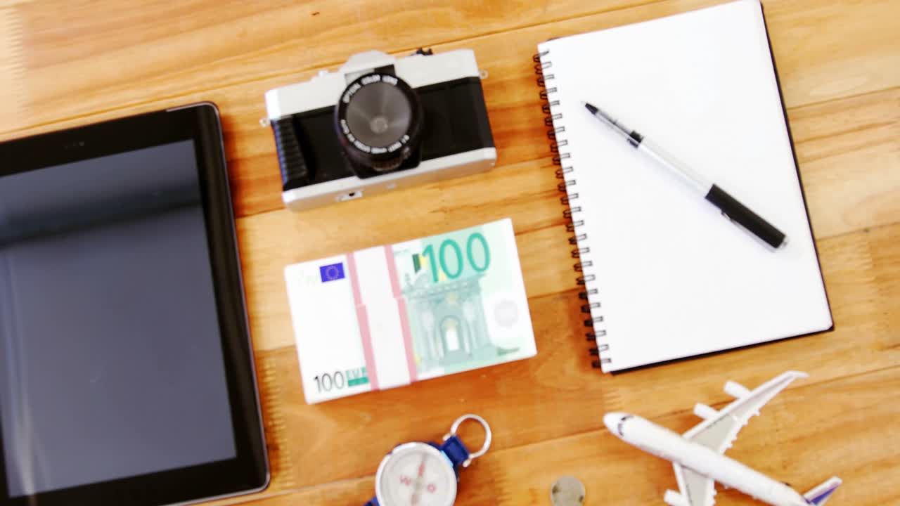 aparatos electrónicos, dólares, lácteos y modelos de aviones en la mesa