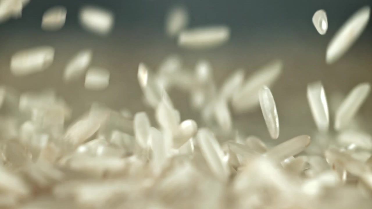 Primer plano de granos de arroz blanco cayendo a cámara lenta