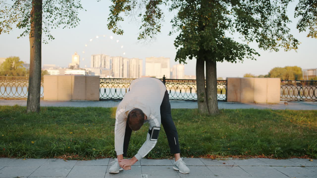 Man Stretching Outdoors in City Park