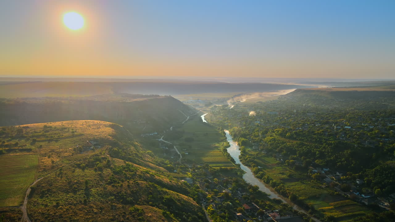 Aerial drone view of the Old Orhei at sunset. Valley with river and fog, village, hills in Moldova