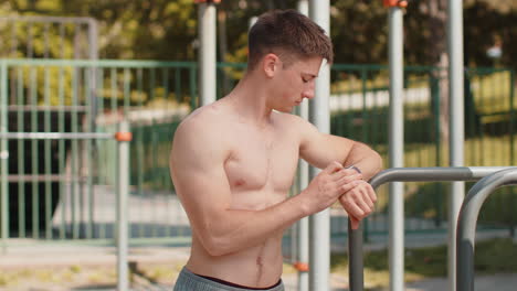 athletic young man using smart watch showing thumbs up like approve gesture checking heart rate